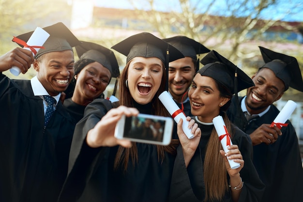 Il mondo del lavoro ecco che arriviamo Scatto di un gruppo di studenti che si fanno selfie con un telefono cellulare il giorno della laurea
