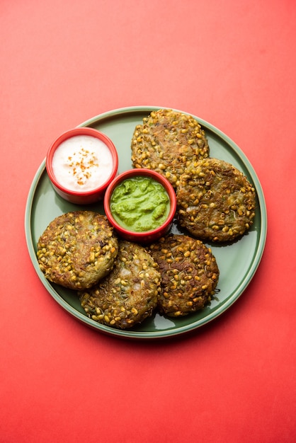 Il moong dal tikki germogliato o polpette è uno spuntino salutare dall'India servito con chutney verde e cagliata