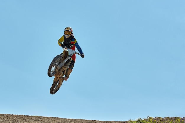 Il motociclista fa un salto estremo contro il cielo