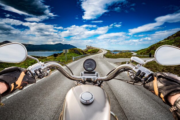 Il motociclista percorre una strada con Atlantic Ocean Road in Norvegia. Visuale in prima persona.