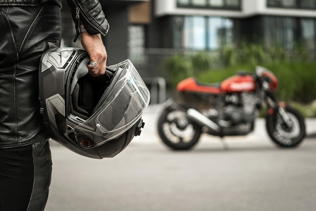 Il motociclista si avvicina alla moto tenendo il casco in mano