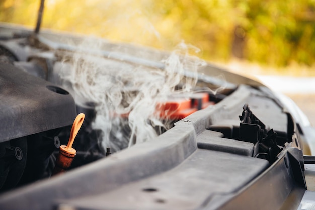 Il motore dell'auto rotta sta fumando Primo piano