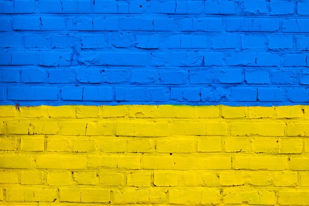 Il muro di mattoni è dipinto con i colori della bandiera nazionale dell'Ucraina su sfondo giallo e blu