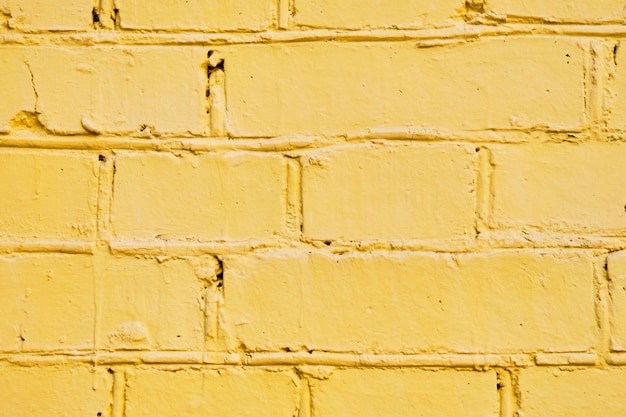 Il muro di mattoni è dipinto di giallo. Sfondo.