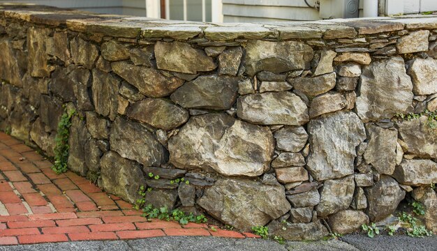 il muro di pietra rustico e senza tempo offre una profondità strutturale che simboleggia la forza, la stabilità e la fine