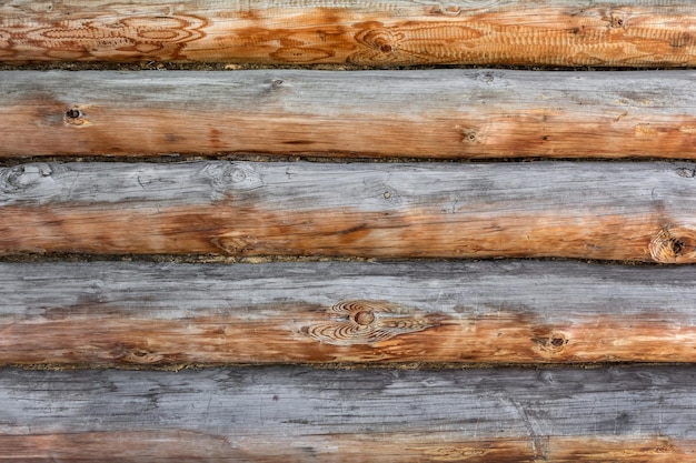 Il muro di tronchi sbiadito e stagionato del fienile. Struttura in legno naturale