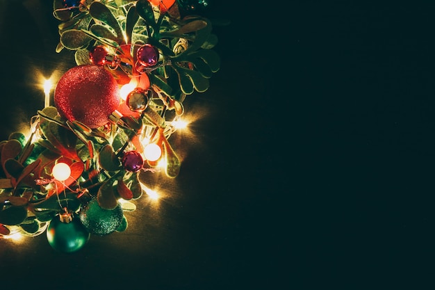 Il Natale si avvolge con luce decorativa su fondo di legno scuro