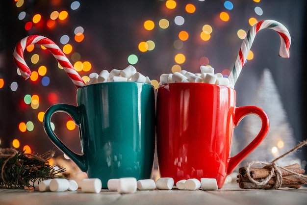 Il Natale si riunisce sullo sfondo con due tazze di cioccolata calda con marshmallow