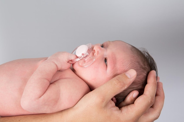 Il neonato è tenuto da suo padre isolato su grigio