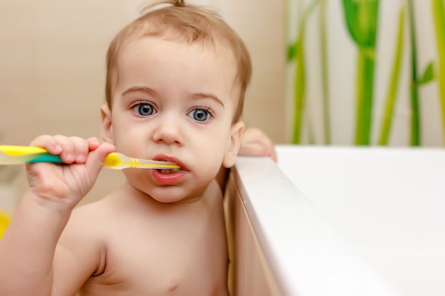 Il neonato si lava i denti in bagno. Concetto di igiene orale.