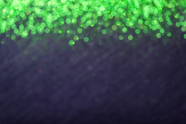 Il nero ha offuscato il fondo per la cartolina d'auguri di Natale con il bokeh delle luci verde.