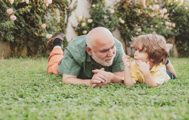 Il nipote abbraccia il nonno felice, il nonno e il nipote bambino ridono e si divertono insieme