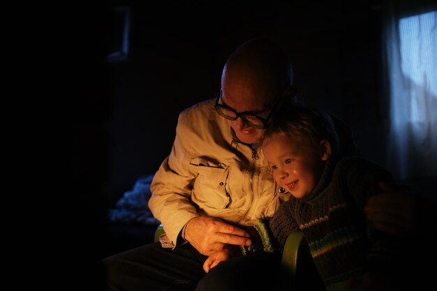 Il nonno abbraccia suo nipote vicino al camino