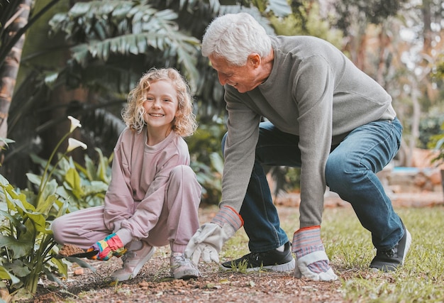 Il nonno conosce i migliori segreti del giardinaggio Inquadratura di un'adorabile bambina che fa giardinaggio con suo nonno