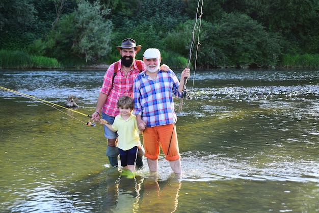 Il nonno e il figlio di pesca a mosca stanno pescando a mosca sul fiume