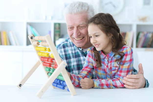 Il nonno insegna a sua nipote a usare l'abaco al chiuso