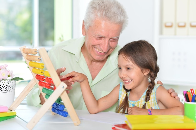 Il nonno insegna a sua nipote a usare l'abaco al chiuso