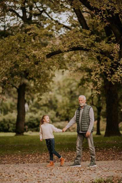 Il nonno trascorre del tempo con sua nipote nel parco il giorno d'autunno