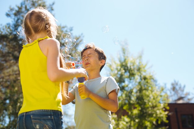 Il nostro intrattenimento. Allerta adorabili bambini che si divertono e fanno bolle di sapone