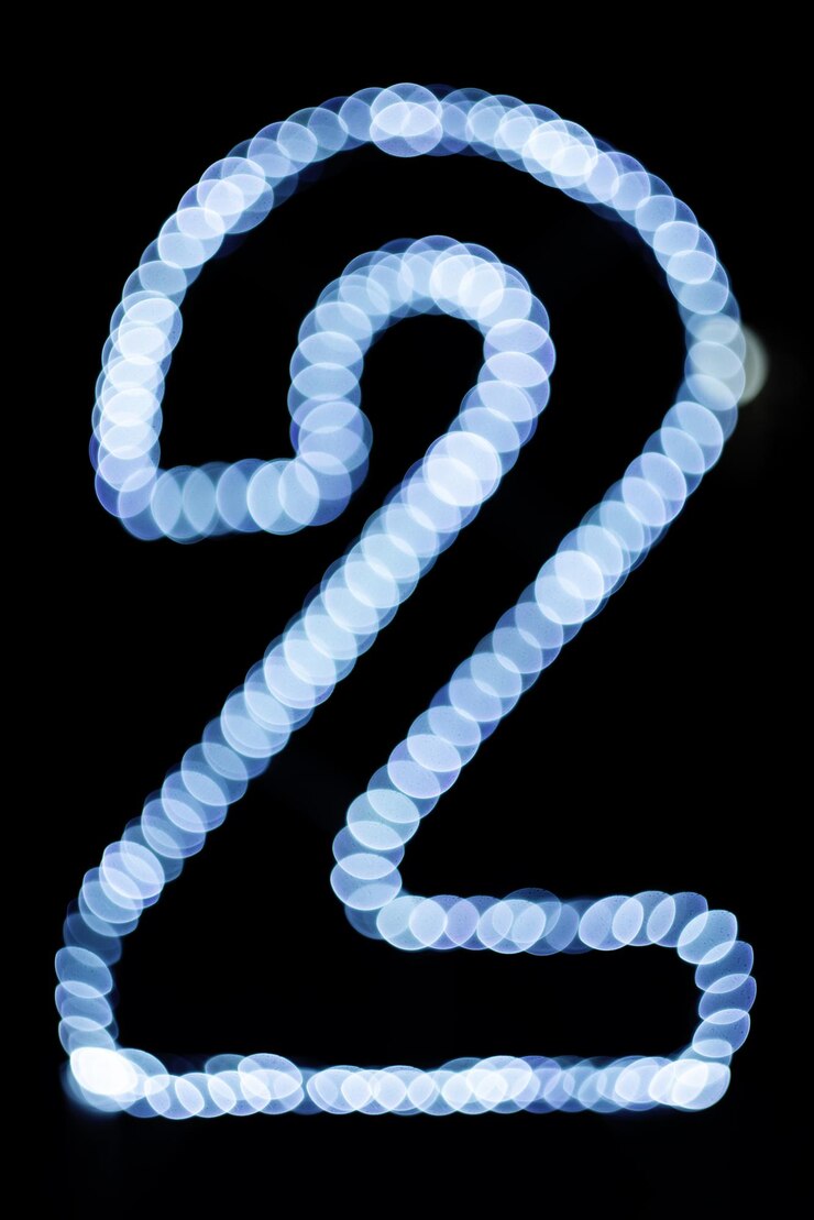 Foto il numero è due. bokeh su sfondo nero. sfondo astratto sfocato