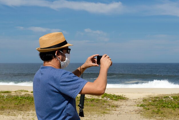 Il nuovo uomo normale di mezza età scatta una foto della spiaggia