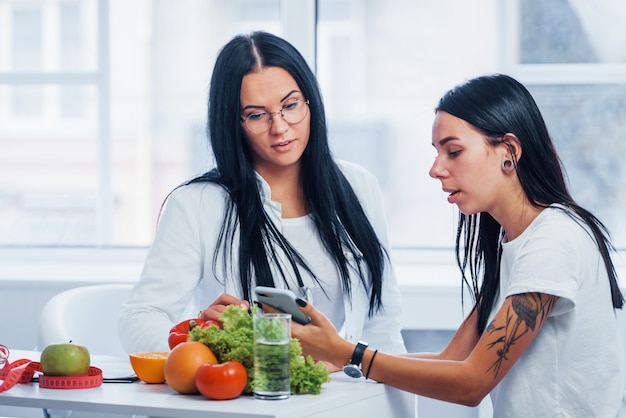 Il nutrizionista femminile dà la consultazione al paziente all'interno dell'ufficio.