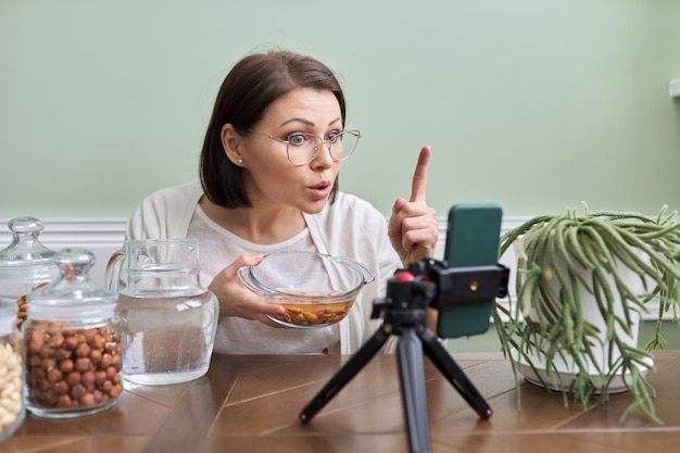 Il nutrizionista parla dei vantaggi dell'ammollo delle noci nell'acqua che registra un video blog vlog