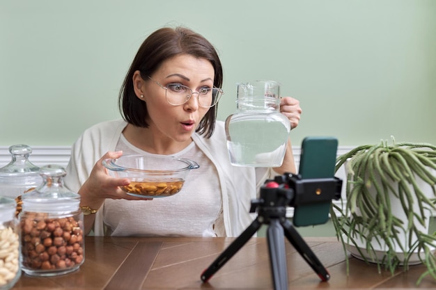 Il nutrizionista parla dei vantaggi dell'ammollo delle noci nell'acqua che registra un video blog vlog