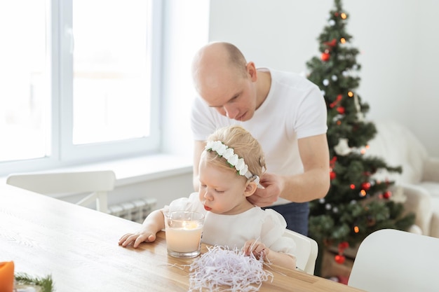 Il padre aiuta a mettere un impianto cocleare per la sua bambina sorda nella spa della copia del soggiorno di Natale