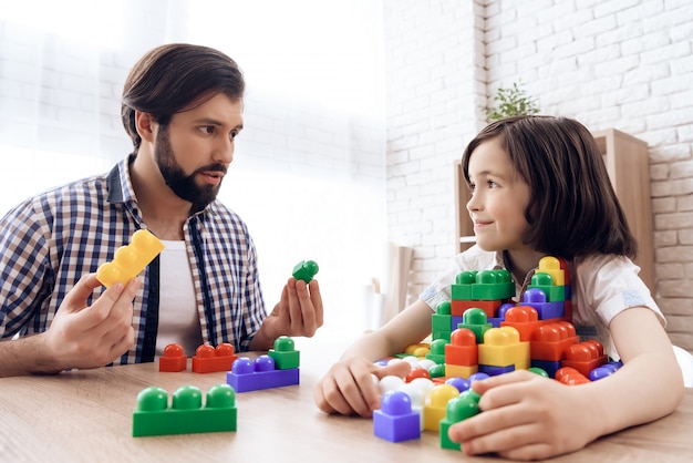 Il padre barbuto chiede al figlio di condividere blocchi colorati giocattolo.