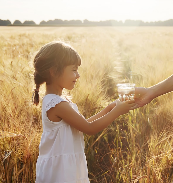 Il padre dà al bambino un bicchiere d&#39;acqua. Messa a fuoco selettiva