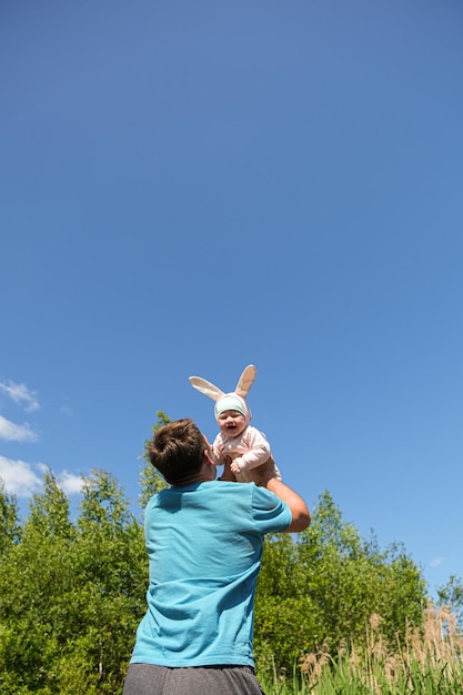 Il padre del bambino felice lancia il suo bambino nel cielo in natura