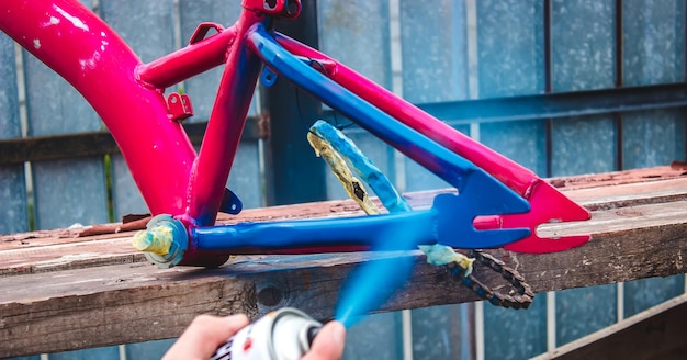 Il padre dipinge una bicicletta per un bambino