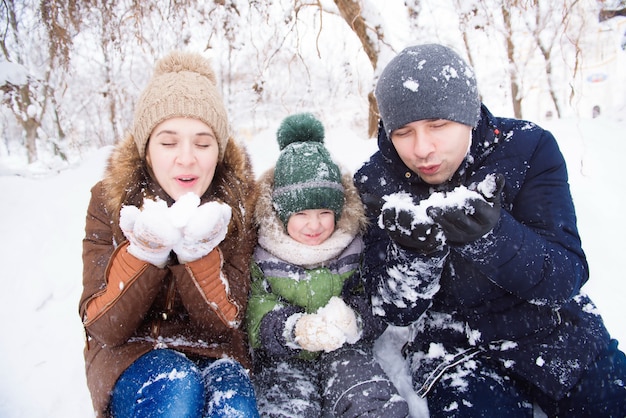 Il padre e la madre cammina con il piccolo figlio in una foresta nell'inverno.