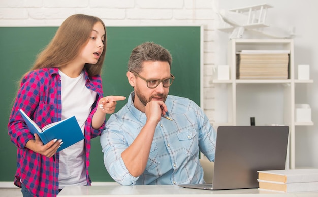 Il padre e la ragazza adolescente studiano l'insegnante privato e la famiglia del quaderno della tenuta del bambino aiutano papà e figlia