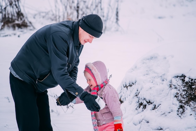 Il padre e la sua piccola figlia carina si divertono all'aperto nelle giornate invernali