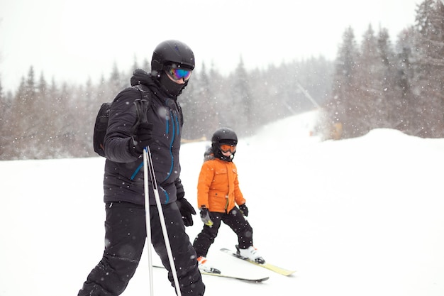 Il padre insegna al figlio a sciare su una pista innevata