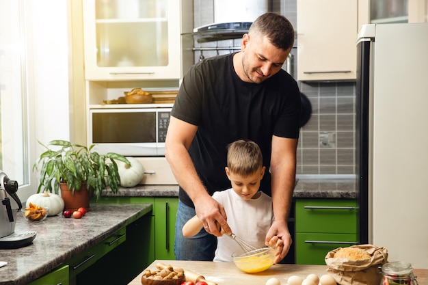 Il padre premuroso insegna a suo figlio a cucinare. Attività indoor. Ottimo tempo con la famiglia