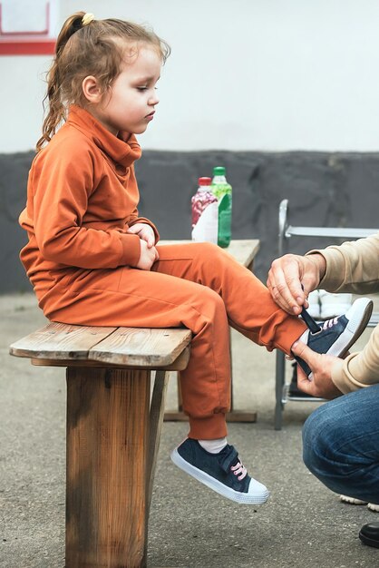 il padre si prende cura del bambino, mette le scarpe per la figlia