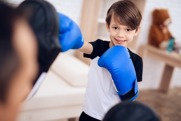 Il padre sta allenando suo figlio boxe.