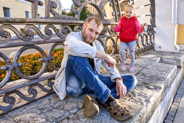 Il padre sta camminando con la bambina nel centro della città