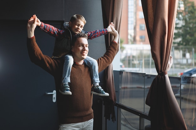 Il padre tiene il figlio tra le braccia. Amore dei genitori, infanzia felice, cura dei bambini.