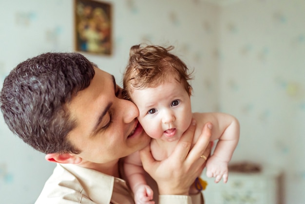 Il padre tiene in mano il bambino nudo