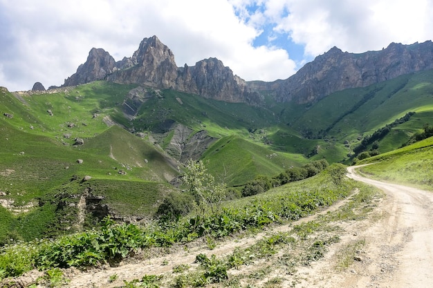 Il paesaggio del verde Aktoprak pass nel Caucaso la strada e le montagne sotto le nuvole grigie KabardinoBalkaria Russia