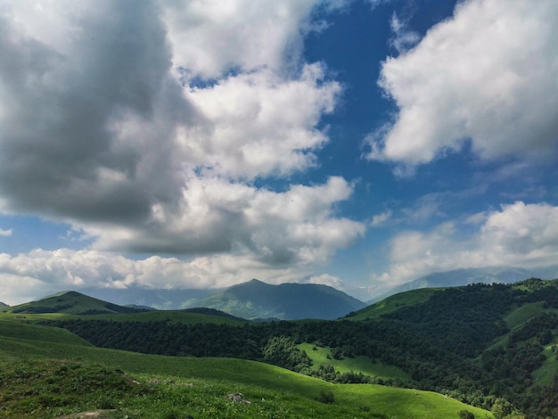 Il paesaggio del verde Aktoprak passa nel Caucaso la strada e le montagne sotto nuvole grigie