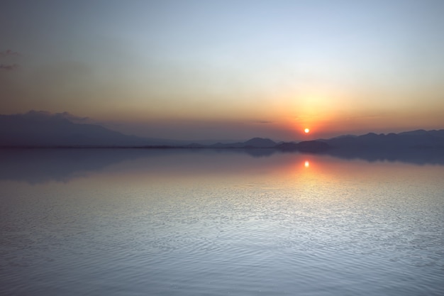 Il paesaggio di un lago con uno sfondo di cielo al tramonto