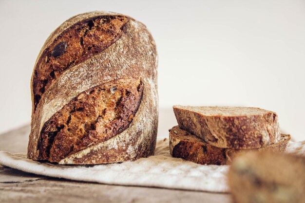 Il pane fresco marrone con i semi viene tagliato a pezzi su uno sfondo di legno vecchio. Copia, spazio vuoto per il testo