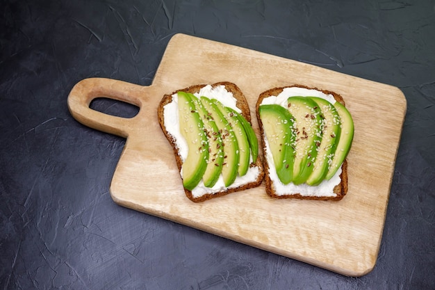 Il pane tostato ai cereali è sui panini da tavola con formaggio a pasta molle