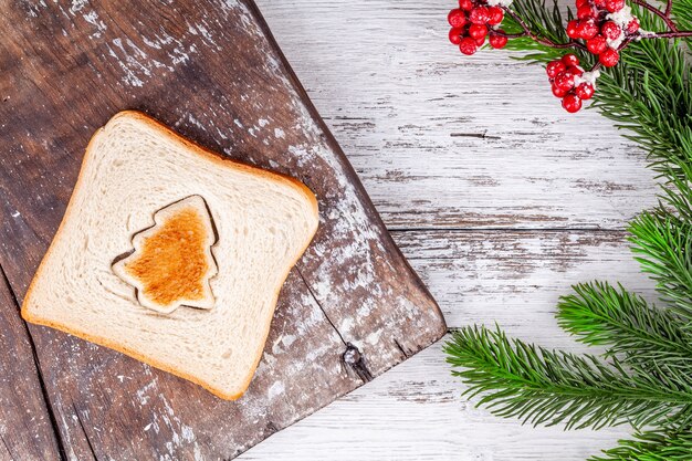 Il pane tostato ha modellato come un abete sul tagliere di legno rustico d'annata