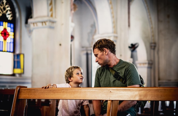 Il papà cristiano racconta al bambino la storia biblica su Gesù le persone sante siedono a Kirk Fede educazione religiosa chiesa moderna festa del papà responsabilità influenza sulla visione del mondo lezioni di vita crescere ragazzo